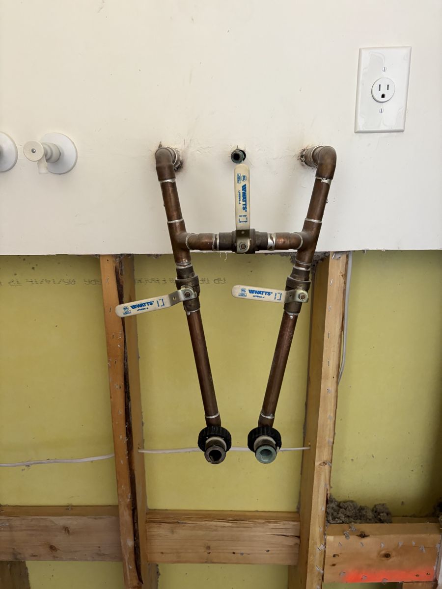 New copper stub-outs with ball valves in an opened wall, ready for the water heater