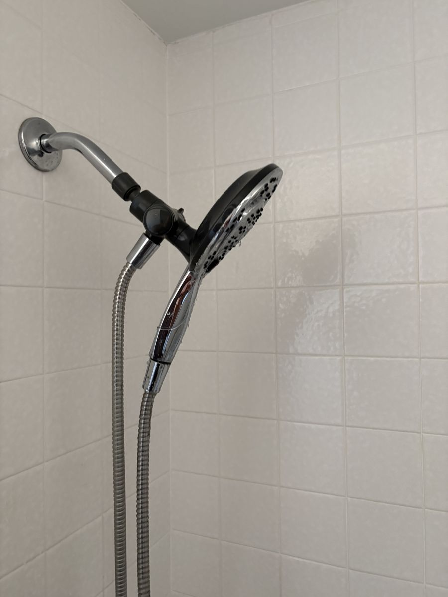 New handheld shower head and slide bar on white tile