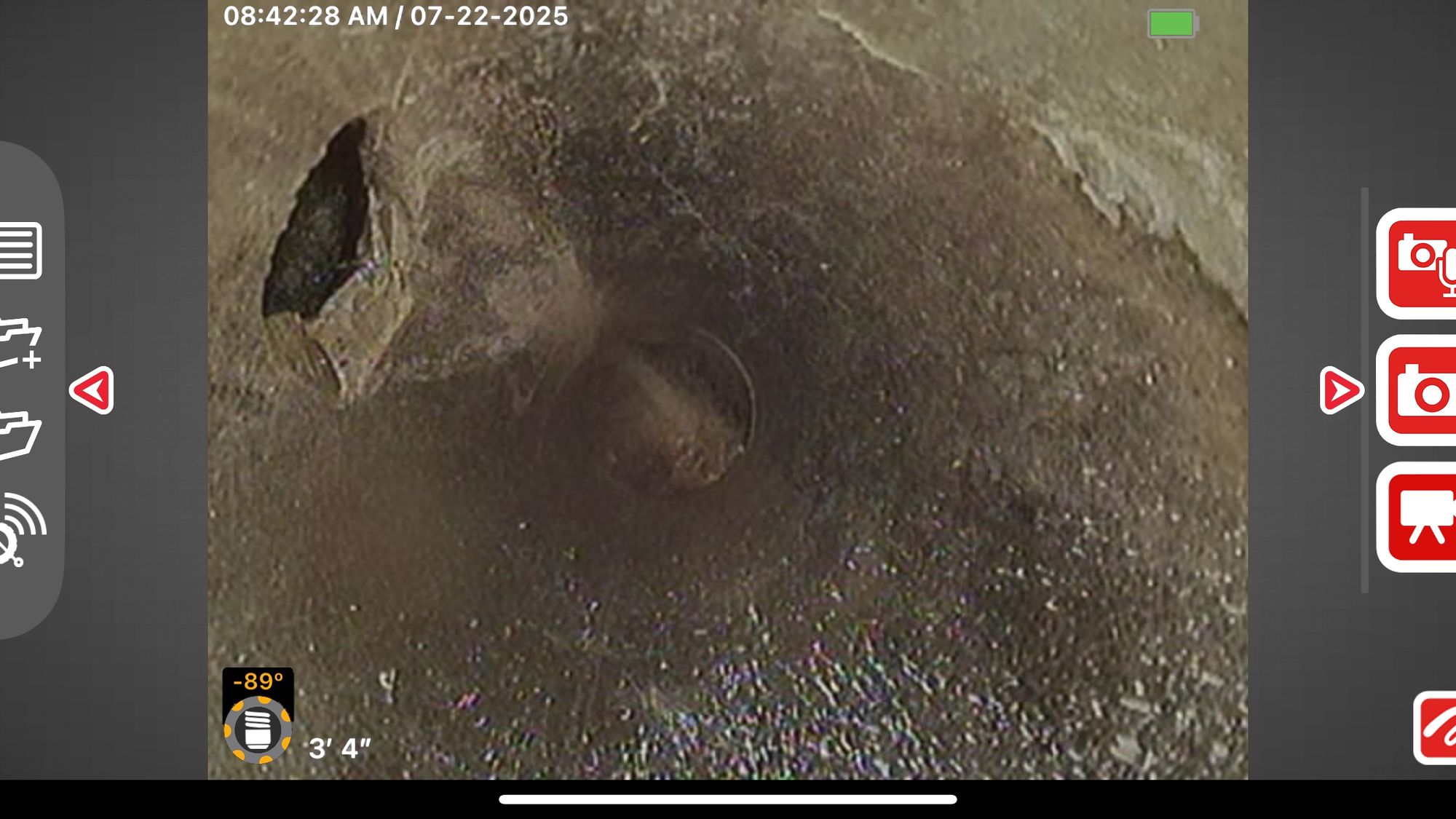 Sewer camera monitor showing the inside of a pipe three feet down the lateral