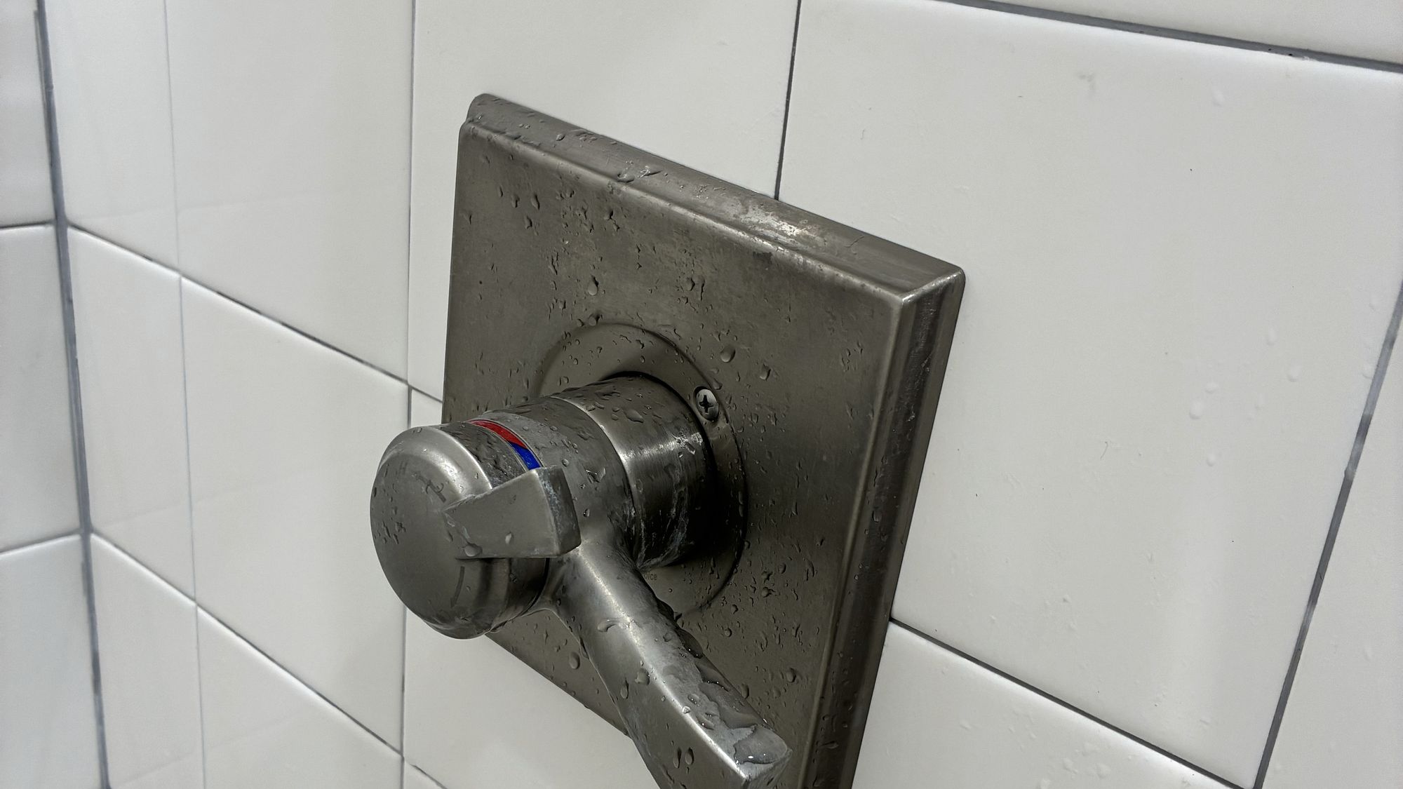 New single-handle shower valve trim on white tile