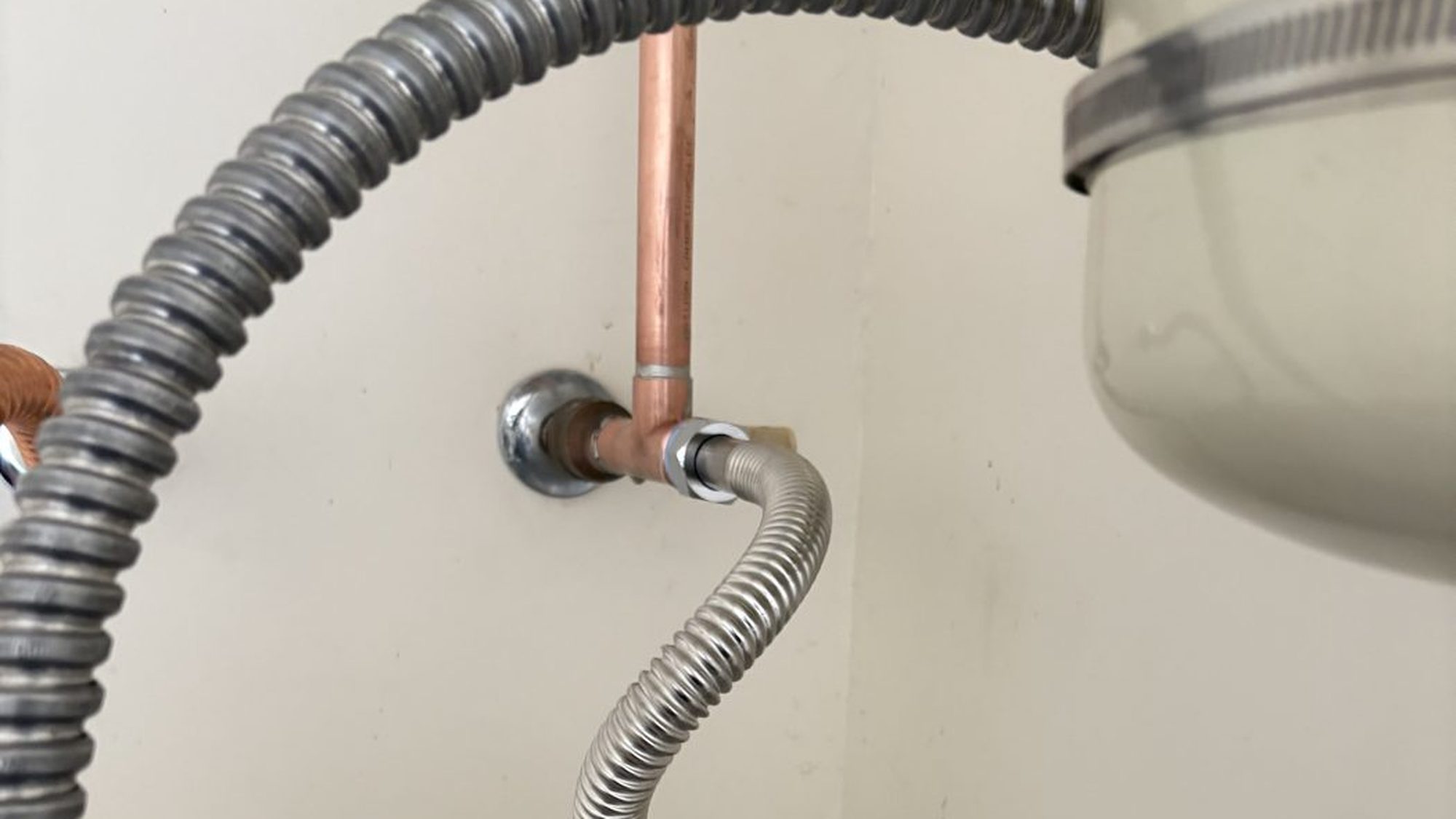 Stainless flex connector and copper supply line feeding a tank water heater