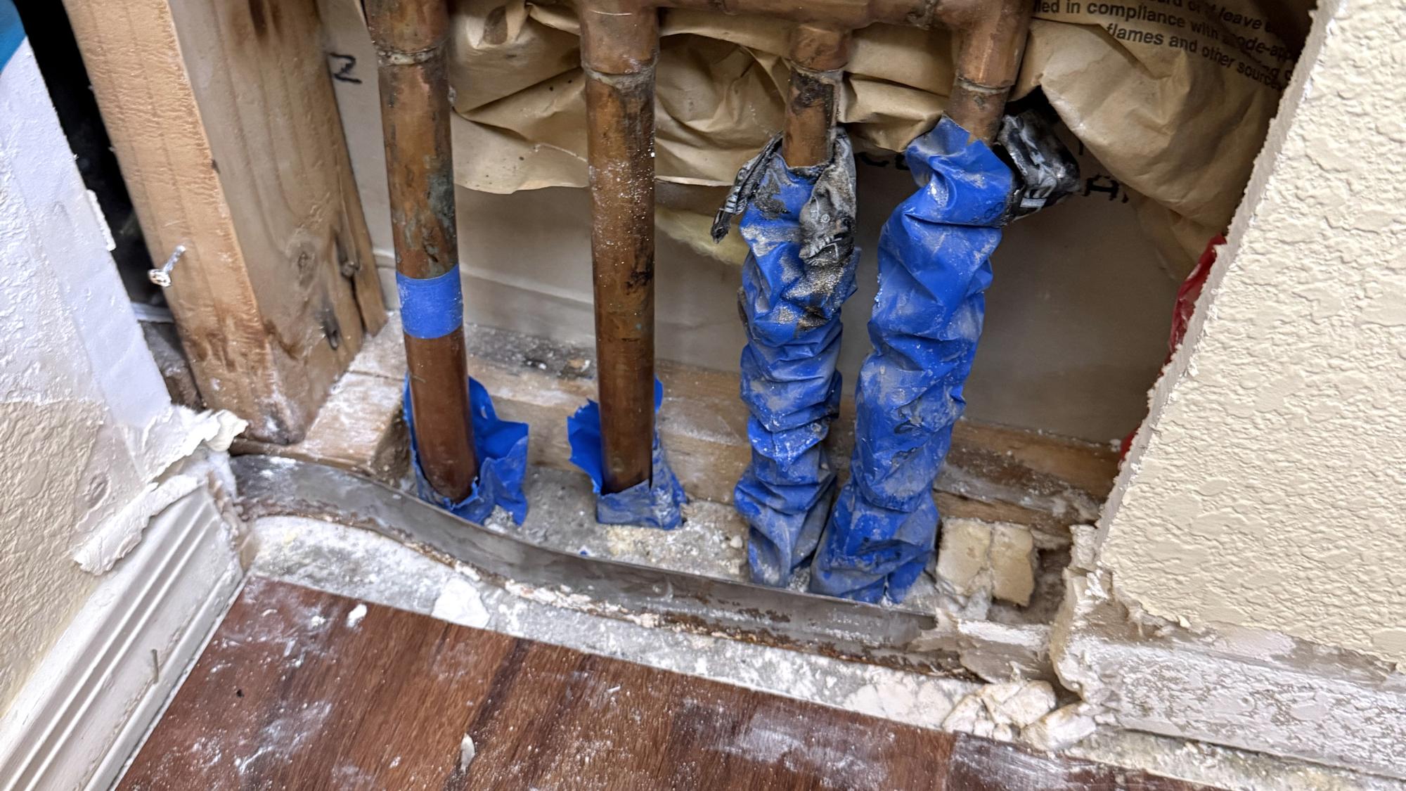 Copper supply manifold exposed in an opened interior wall during a whole-home repipe
