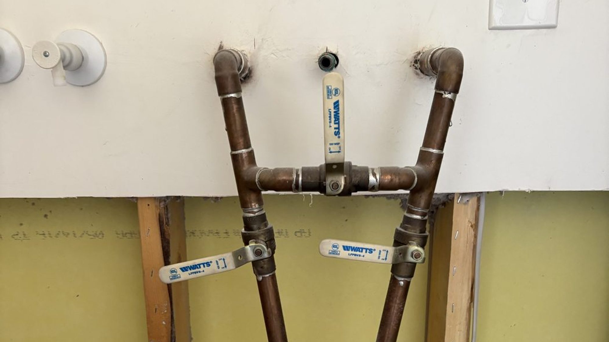New copper sink stub-outs with shutoff valves in an opened wall