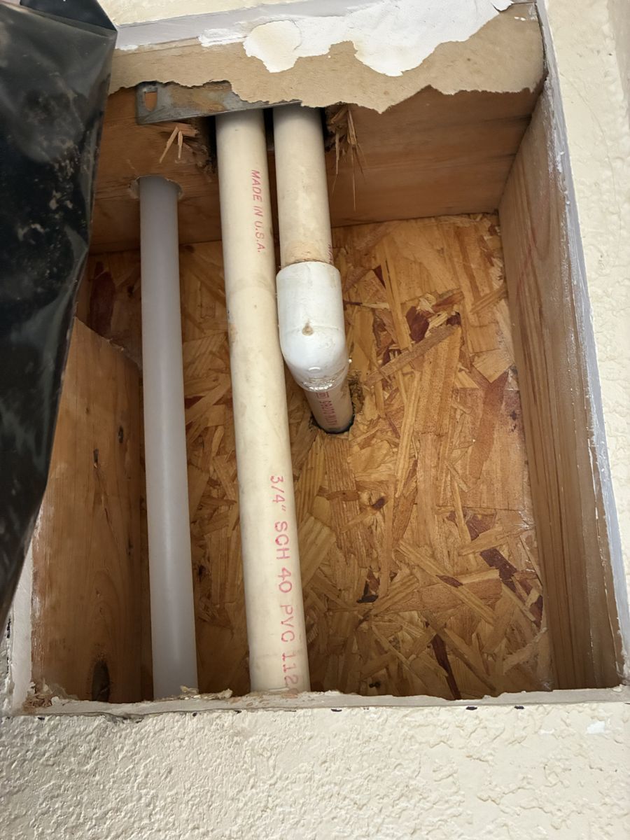 Three-quarter inch PVC supply lines exposed in an opened wall during a repipe